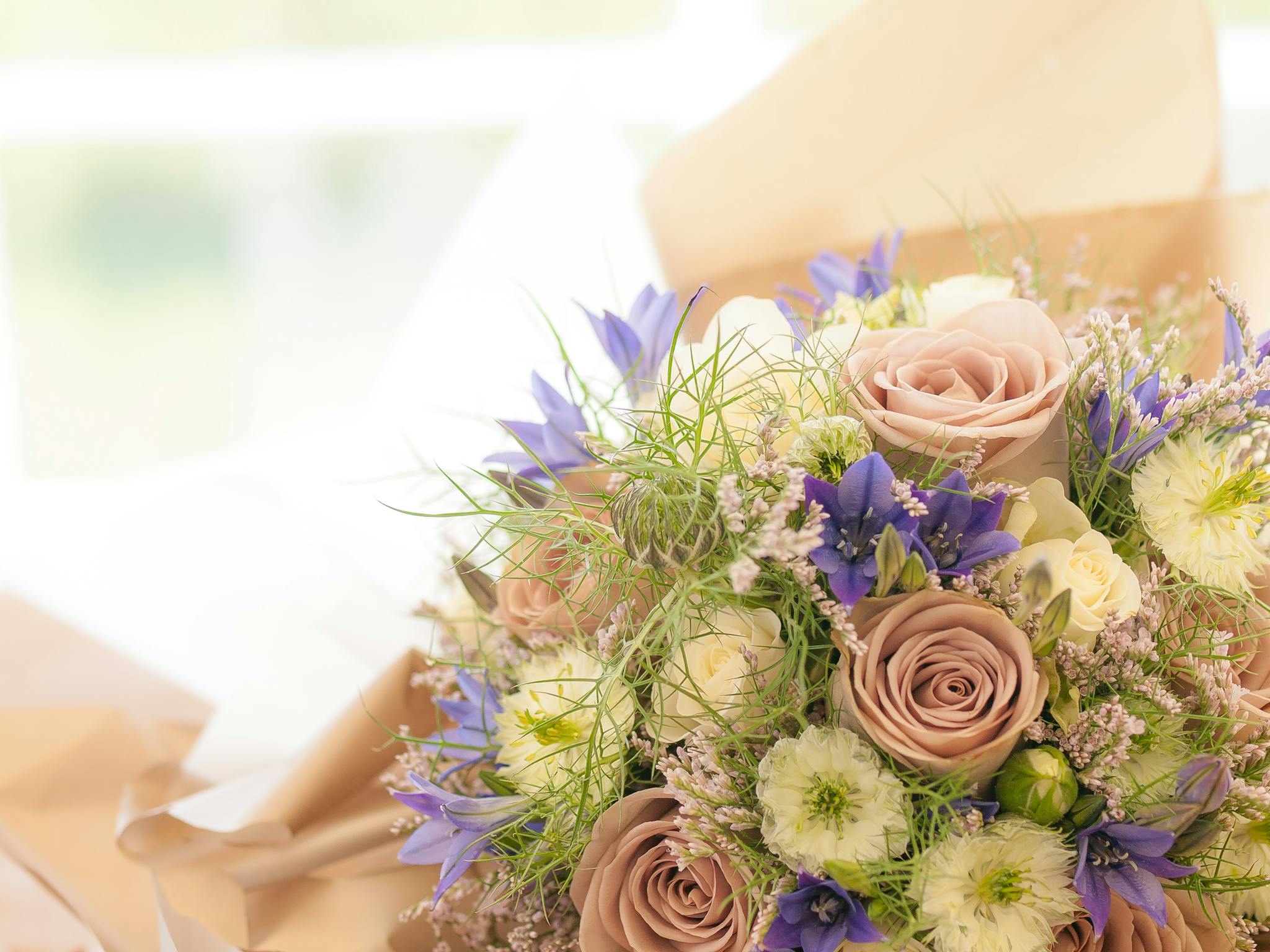 A beautiful bouquet with roses and wildflowers in soft pastel colors, perfect for celebrations.
